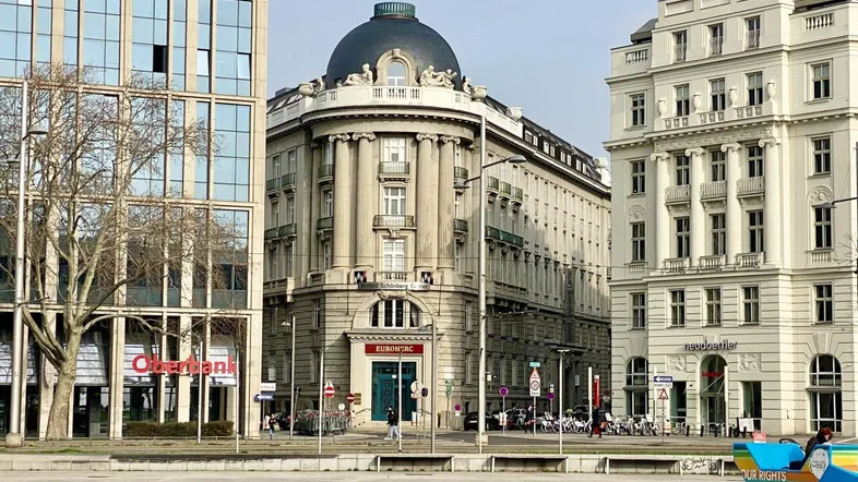 Historisches Gebäude mit markanter Kuppel und klassischer Architektur an einer städtischen Kreuzung.
