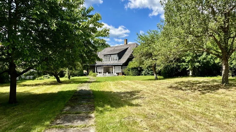 Großzügiger Gartenbereich mit altem Baumbestand und Blick auf das charmante Landhaus.