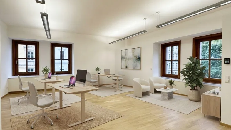 Heller Büroraum mit Holzboden, großen Fenstern und moderner Einrichtung für mehrere Arbeitsplätze.