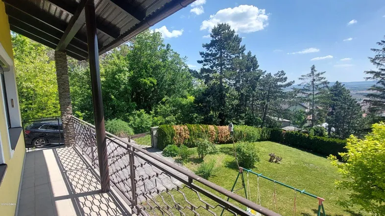 Geräumiger Balkon mit Blick auf den grünen Garten und die weite Landschaft.