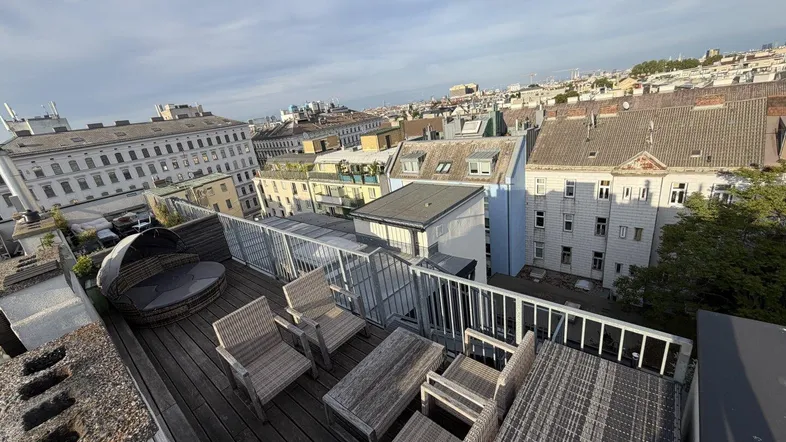 Große Dachterrasse mit bequemen Outdoor-Möbeln und weitem Blick über die Stadt.