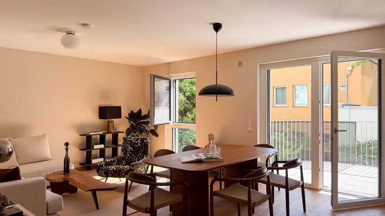Heller, offener Wohn- und Essbereich mit Holzboden, modernen Möbeln und direktem Zugang zur Terrasse.