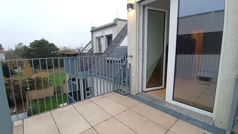 Geräumiger Balkon mit Fliesenboden und Blick auf die Umgebung, ideal für entspannte Stunden im Freien.