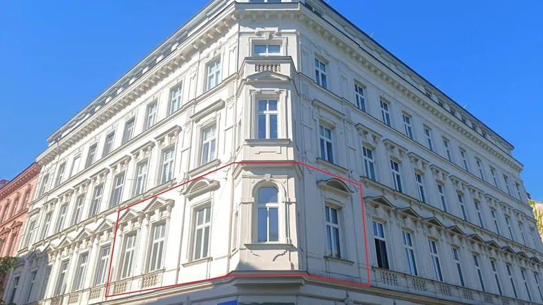 Historisches Eckgebäude mit klassischer Architektur und vielen Fenstern in der Stadt.