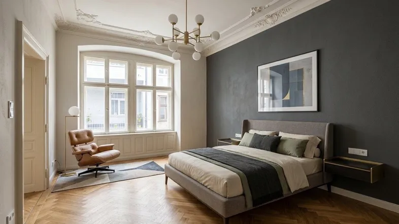 Elegantes Schlafzimmer mit Fischgrätparkett, Stuckdecke und einer dunklen Akzentwand.