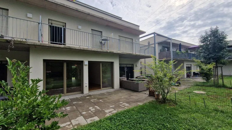Moderne Wohnanlage mit privater Terrasse und Gartenbereich, umgeben von Grün.