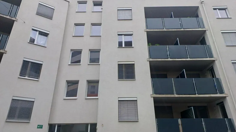 Moderne Wohnhausfassade mit mehreren Balkonen und Fenstern, in einem städtischen Umfeld.