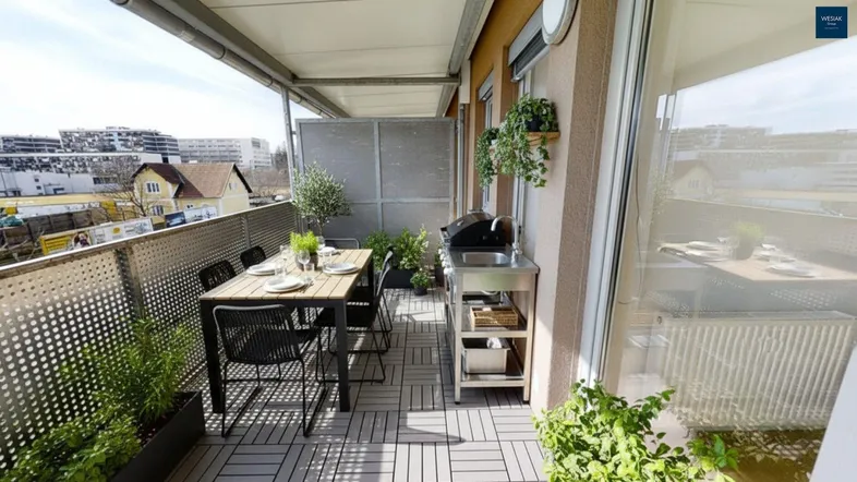 Möblierter Balkon mit Esstisch, Grill und Pflanzen, ideal für Mahlzeiten im Freien.