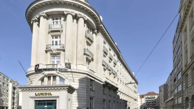 Prächtiges historisches Gebäude mit klassischer Architektur, Säulen und Balkonen an einer Stadtstraße.