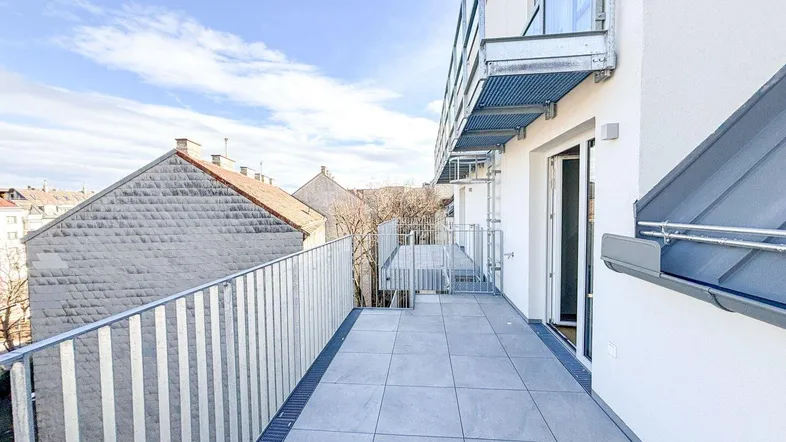 Geräumiger Balkon mit modernen Fliesen und Metallgeländer, bietet einen weiten Blick auf die Umgebung.