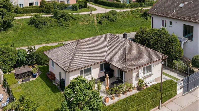 Luftaufnahme des Einfamilienhauses mit großem Garten, Terrasse und umliegender Wohnbebauung.