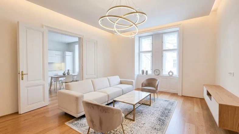 Helles Wohnzimmer mit modernem Design, Holzboden und Zugang zu einem offenen Küchenbereich.