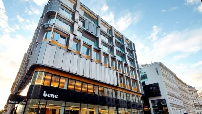 Modernes Geschäftsgebäude mit Glasfassade und markanter Architektur bei Tageslicht in der Stadt.