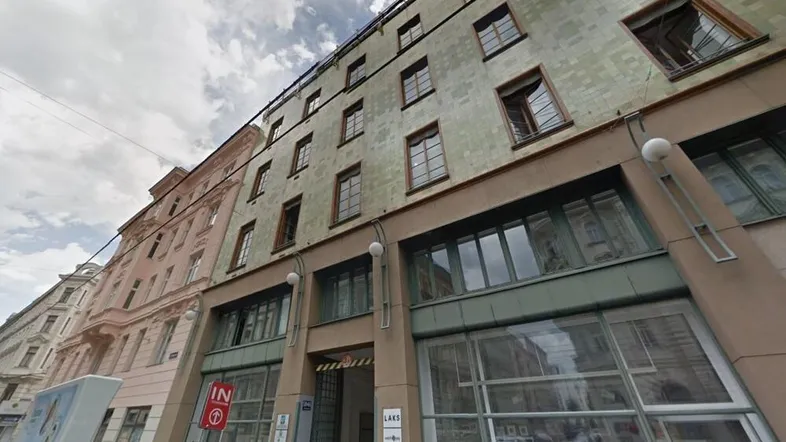 Historisches Gebäude mit einer Mischung aus Geschäftsflächen im Erdgeschoss und Wohnungen in den oberen Etagen, typisch für die Stadtarchitektur.