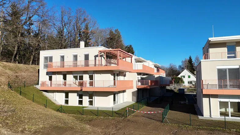 Moderne Neubauwohnungen mit mehreren Etagen und Balkonen in Hanglage.