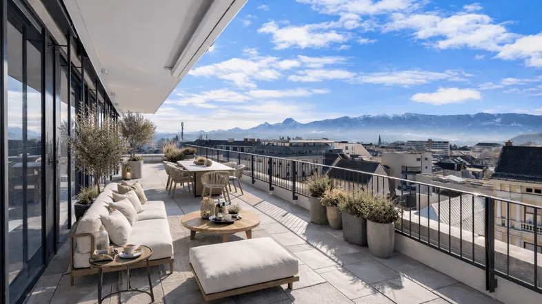 Große, möblierte Dachterrasse mit Essbereich, Lounge und weitem Blick auf die Berge und die Stadt.