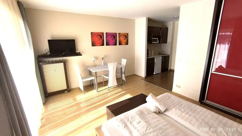 Helles Studio-Apartment mit Schlafbereich, Esstisch und integrierter Küchenzeile, ideal für Einzelpersonen oder Paare.
