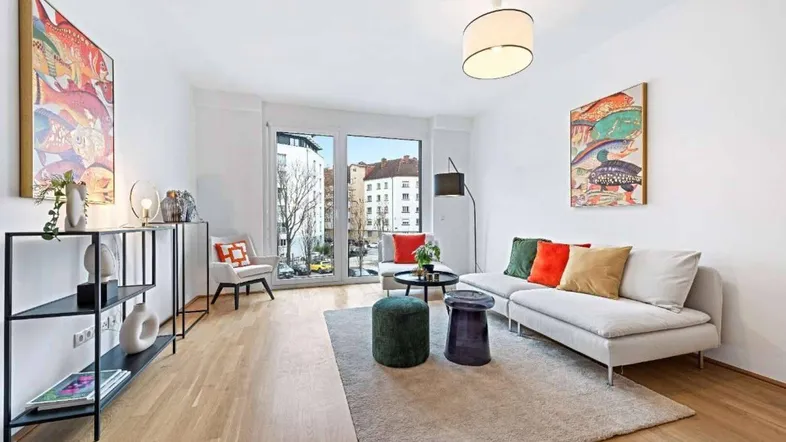 Helles Wohnzimmer mit Holzboden, großen Fenstern und moderner Einrichtung sowie Stadtblick.