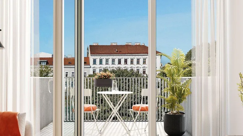 Heller Balkon mit Sitzgelegenheiten und Blick auf die Stadtgebäude.