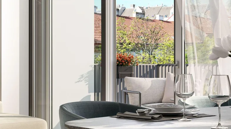 Moderner Essbereich mit gedecktem Tisch und Zugang zu einem Balkon mit Blick auf die Stadt.