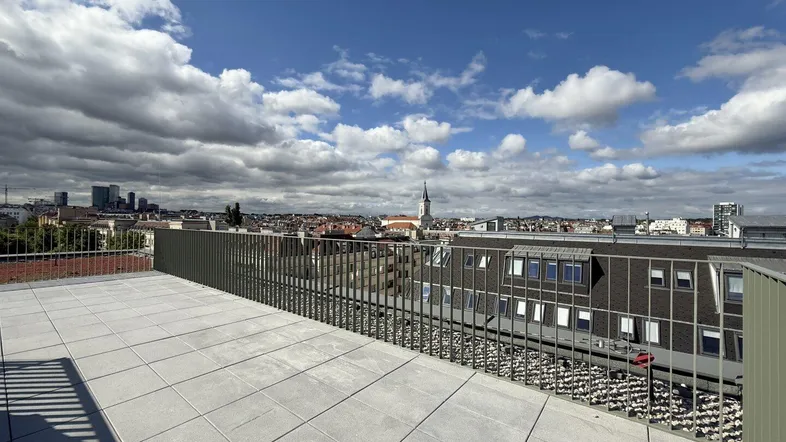 Geräumige Dachterrasse mit Fliesenboden und weitem Blick über die Stadt.