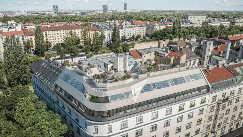 Moderne Architektur mit geschwungener Dachkonstruktion und Dachterrassen in urbaner Umgebung.