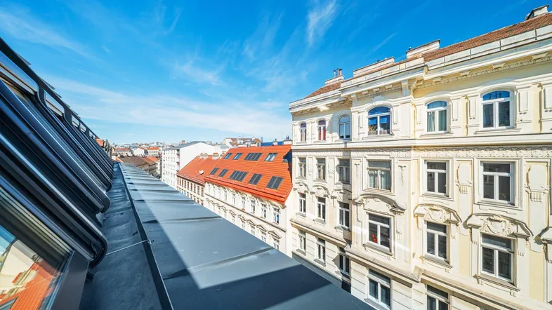 Blick über die Dächer der Stadt mit blauer Himmel und angrenzenden historischen Gebäuden.