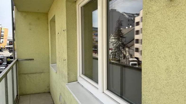 Schmaler Balkon mit Fliesenboden und Blick auf die Stadt, ideal für Pflanzen oder einen kleinen Sitzbereich.