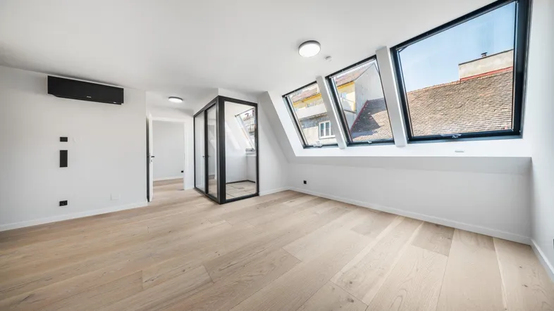 Helles Dachzimmer mit Holzboden, großen Dachfenstern und Klimaanlage in modernem Stil.