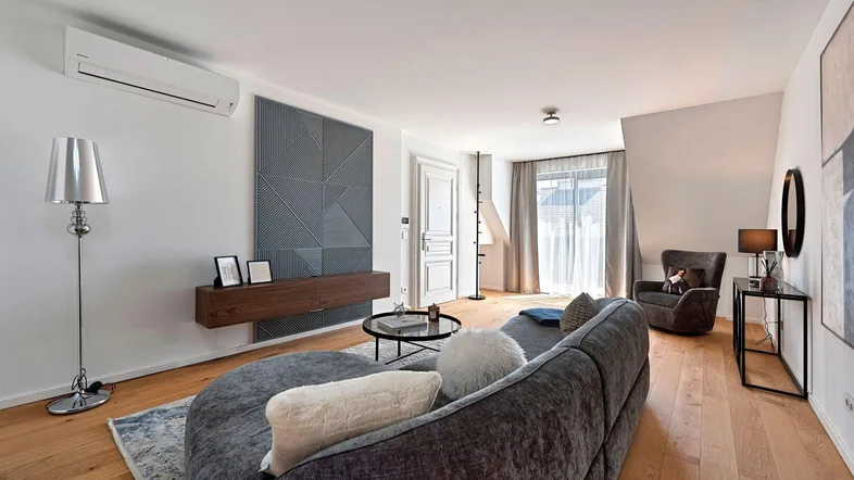Modernes Wohnzimmer mit bequemer Couch, Holzboden und Klimaanlage, hell und einladend gestaltet.