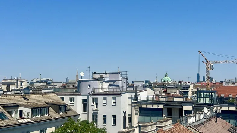 Panoramablick über die Dächer der Stadt mit klarem blauem Himmel und urbaner Architektur.