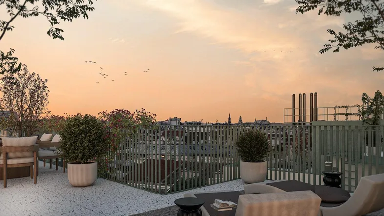 Großzügige Dachterrasse mit bequemen Lounge-Möbeln und weitem Blick über die Stadt bei Sonnenuntergang.