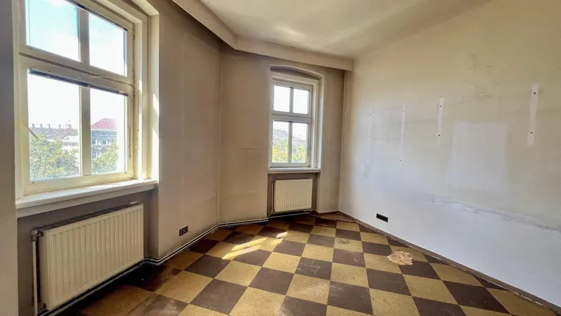 Unrenovierter Raum mit kariertem Boden und zwei Fenstern, bereit für die Neugestaltung.