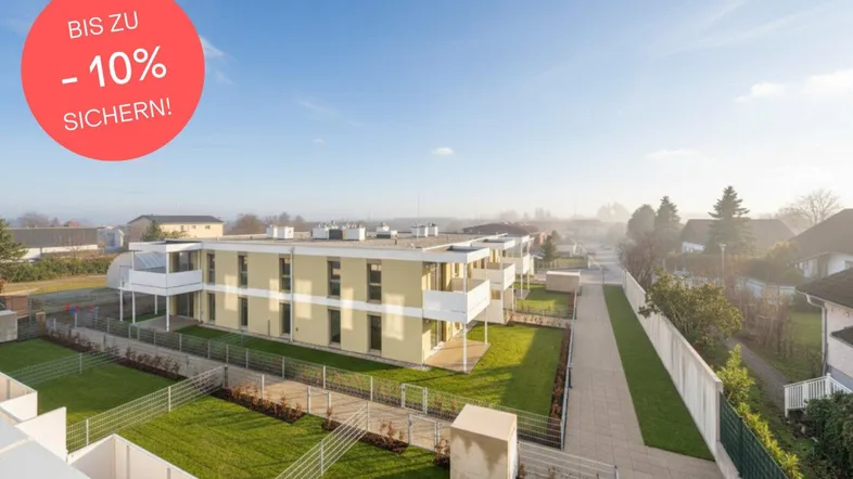 Luftaufnahme eines modernen Wohnkomplexes mit mehreren Gebäuden und gepflegten Grünflächen.
