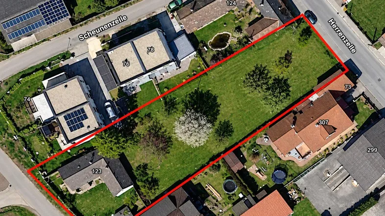 Luftaufnahme eines Grundstücks mit umliegender Bebauung und Straßen.