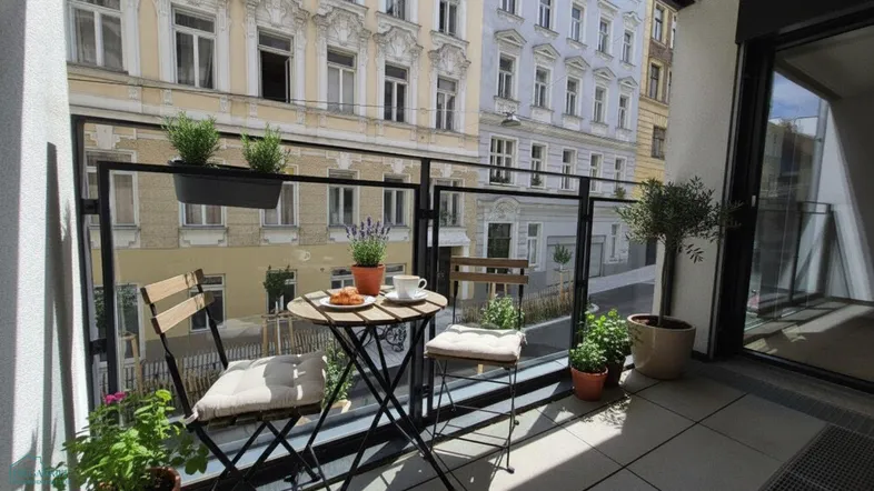 Gemütlicher Balkon mit Sitzgelegenheiten und Pflanzen, bietet einen Blick auf die Stadtstraße.