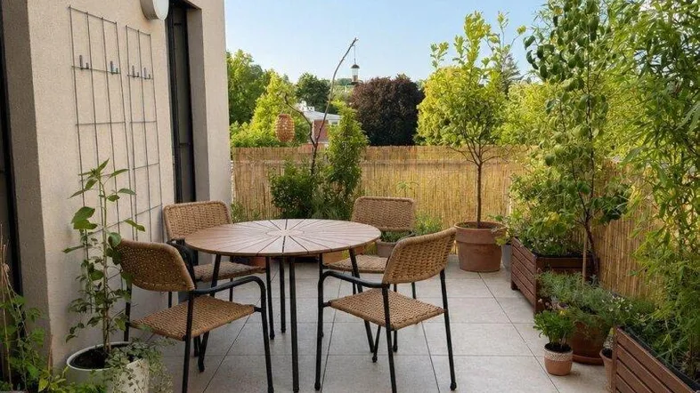 Moderne Dachterrasse mit Esstisch und Pflanzen, ideal für entspannte Stunden im Freien.
