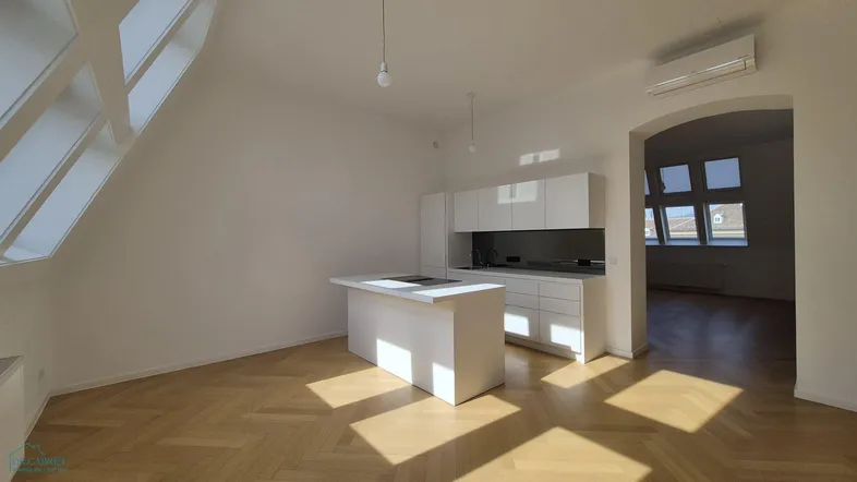 Moderne offene Küche mit weißer Einbauküche, Kochinsel und Fischgrätparkett unter großen Dachfenstern.