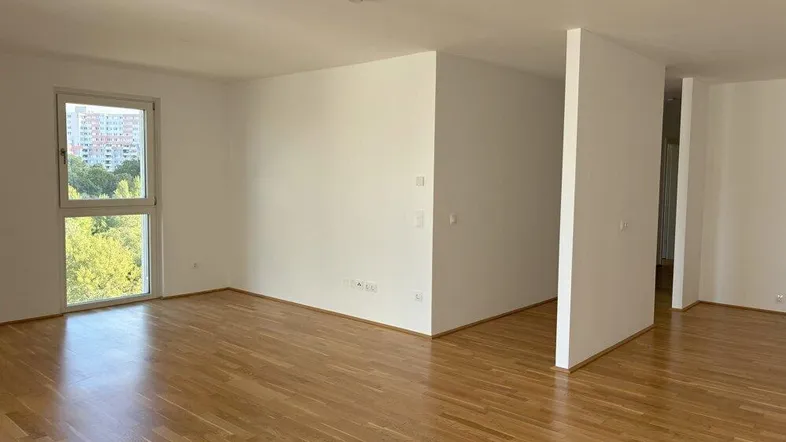 Helles Wohnzimmer mit Parkettboden und Blick ins Grüne, bereit zur individuellen Gestaltung.