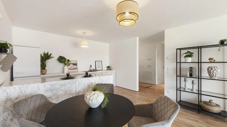 Heller offener Wohn- und Essbereich mit Holzboden und Marmortheke, ideal für modernes Wohnen.