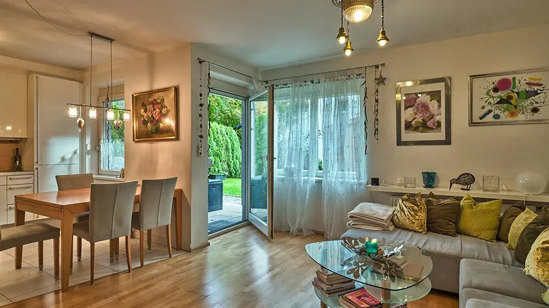 Helles Wohn- und Esszimmer mit Holzboden und direktem Zugang zur Terrasse und zum Garten.