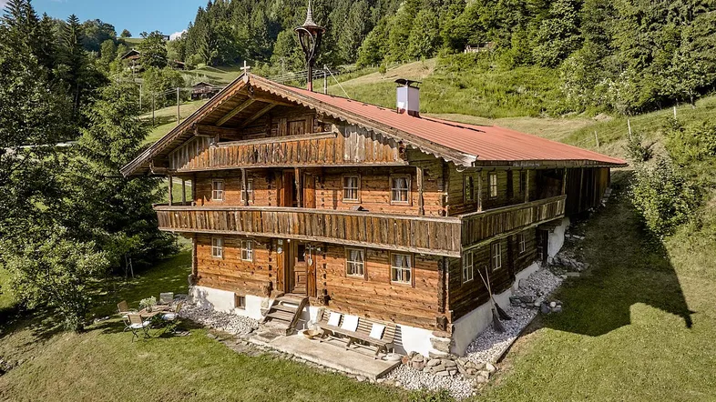 Traditionelles Holzchalet in alpiner Landschaft mit mehreren Balkonen und Bergblick.