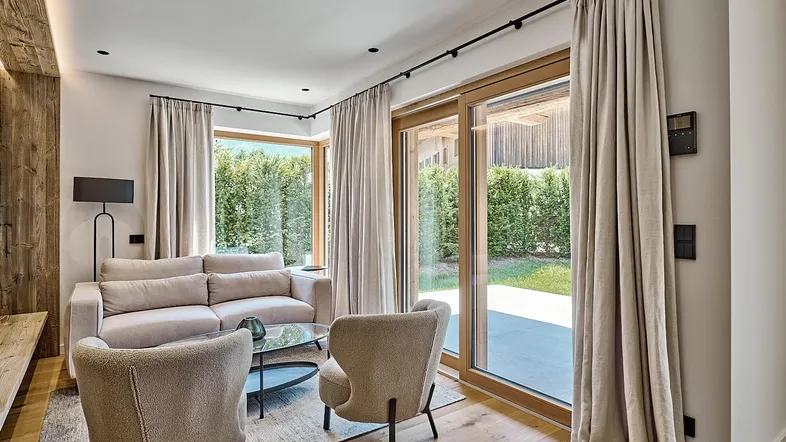 Helles Wohnzimmer mit Holzboden, bequemen Möbeln und direktem Zugang zum Gartenbereich.
