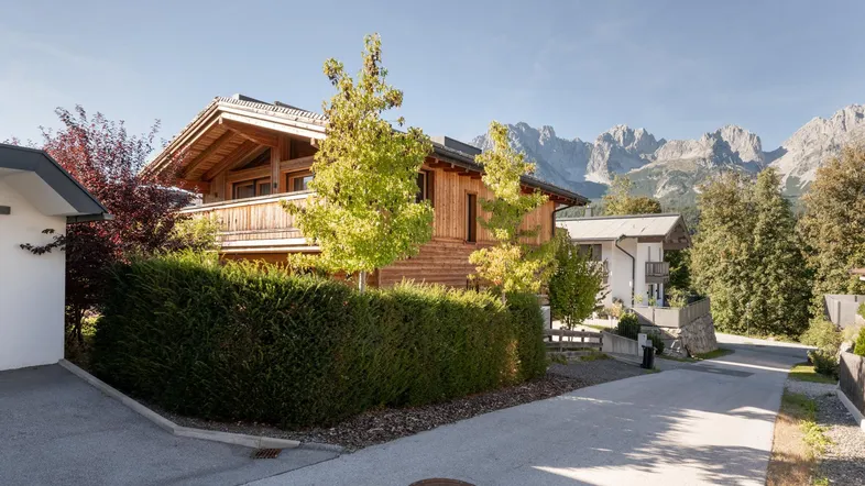 Holzchalet mit traditioneller Architektur und Blick auf die umliegende Berglandschaft.