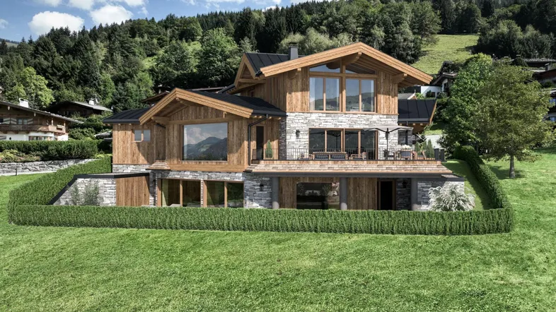 Luxuriöses Chalet mit Holz- und Steinfassade, umgeben von grüner Natur und Bergen.