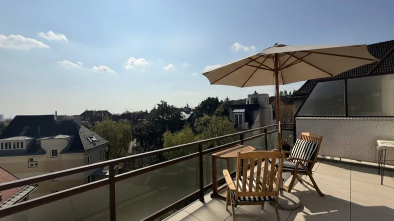 Sonnige Terrasse mit Gartenmöbeln und Sonnenschirm, ideal für entspannte Stunden mit Panoramablick.