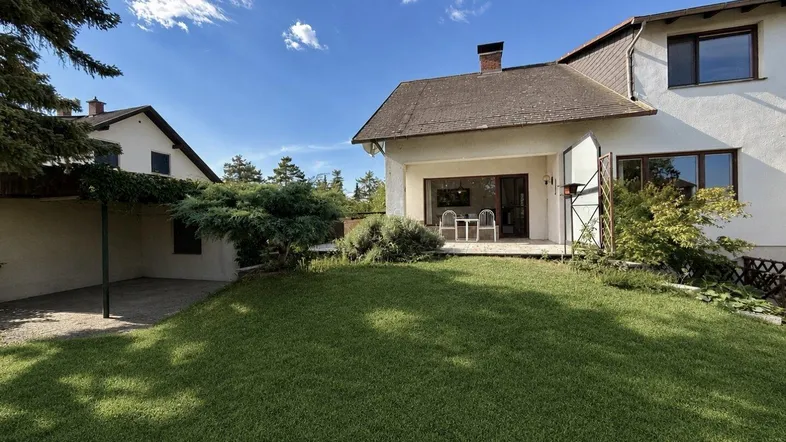 Großer Garten mit Rasenfläche und Terrasse, ideal für Entspannung im Freien.