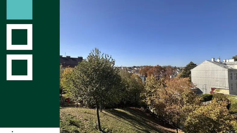 Blick auf eine grüne Umgebung mit Bäumen und umliegenden Gebäuden unter blauem Himmel.