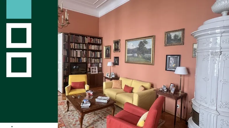 Elegantes Wohnzimmer mit Stuckdecke, Kachelofen und klassischem Parkettboden.