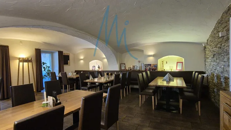 Geräumiger Restaurantbereich mit gewölbten Decken, Holztischen und bequemen Sitzgelegenheiten, ideal für Gäste.